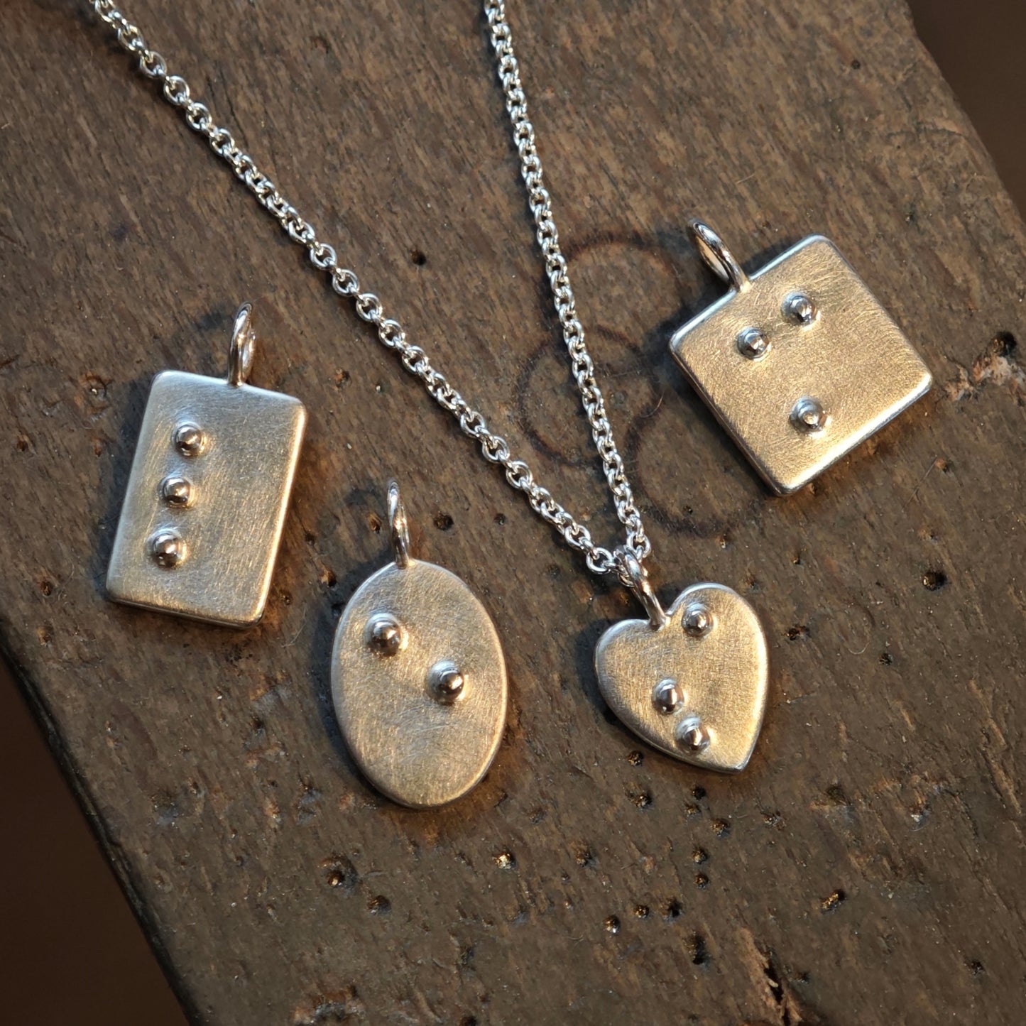 Silberschmuck mit Brailleschrift, Blindenschrift als ID Kettenanhänger, vier handgefertigte Anhänger auf dem Feilnagel der Goldschmiedemeisterin