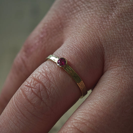 Ring am Finger getragen: Goldring mit Rubin und Hammerschlag