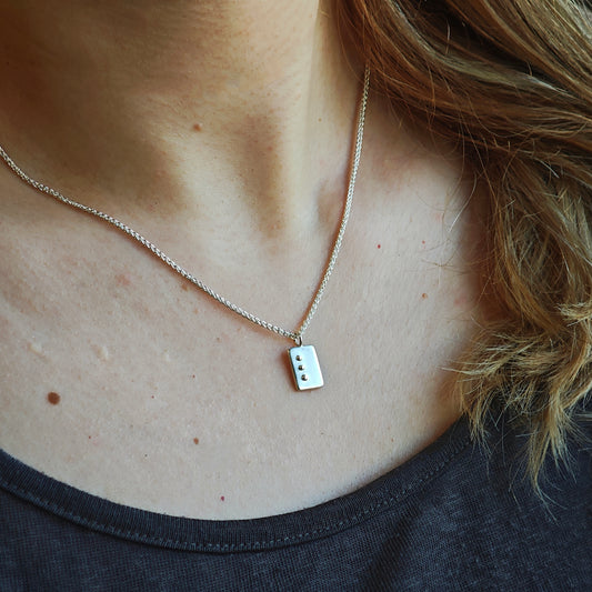 Getragene Kette mit Blindenschrift-Anhänger aus Silber, rechteckige, längliche Form