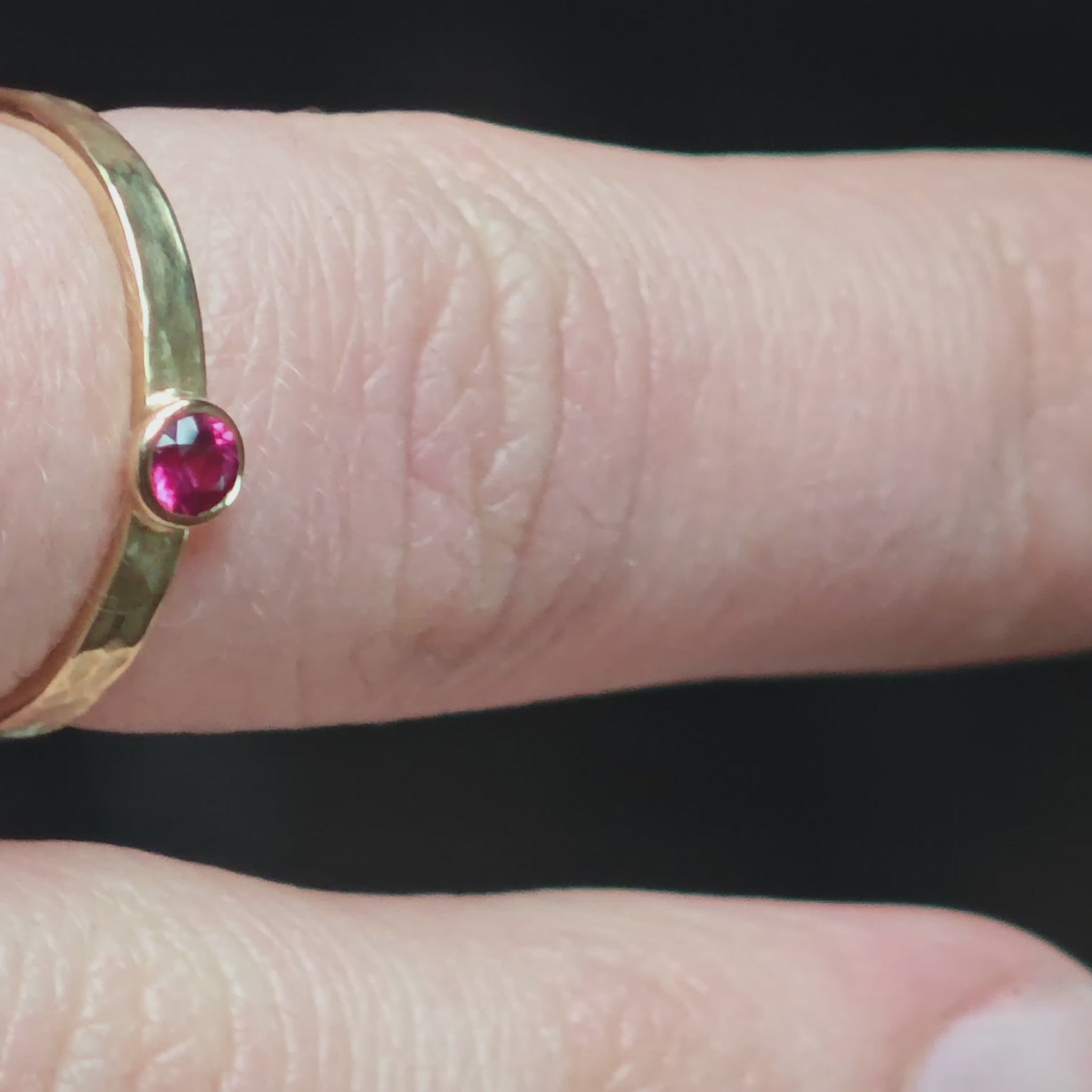 Goldring mit pinkem Rubin am Finger getragen in Bewegung
